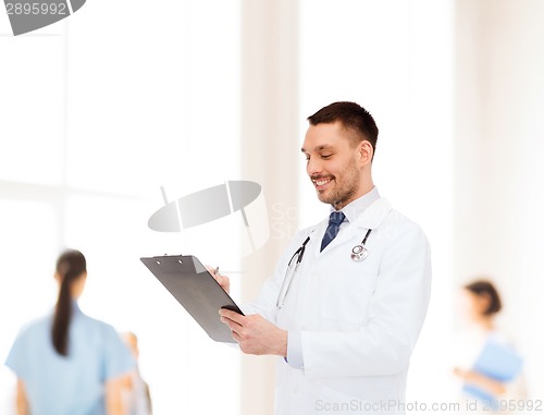 Image of smiling male doctor with clipboard and stethoscope