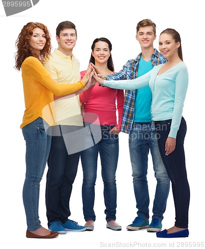 Image of group of smiling teenagers making high five