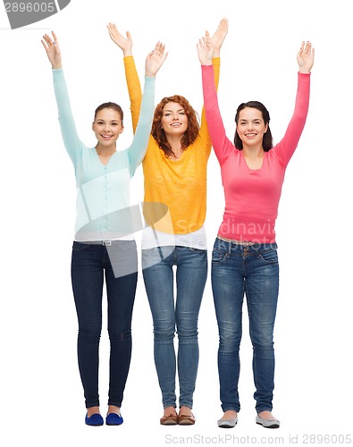 Image of group of smiling teenagers with raised hands