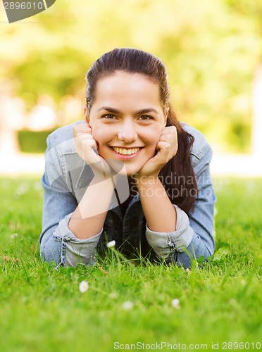 Image of smiling young girl lying on grass