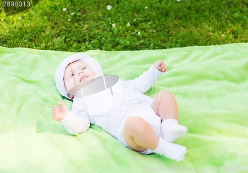 Image of smiling baby lying on floor and looking up