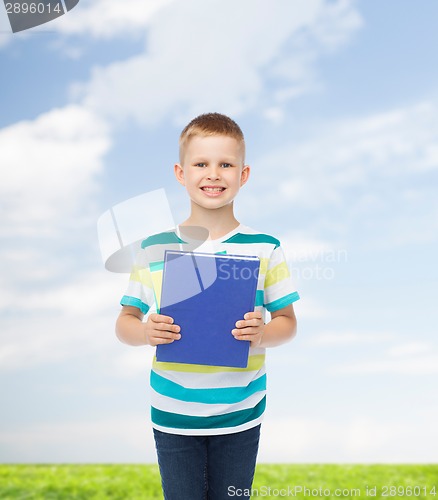 Image of smiling little student boy with blue book