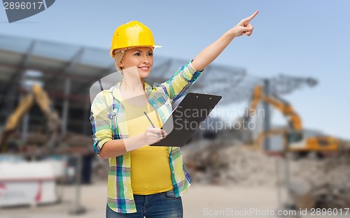 Image of smiling woman in helmet with clipboard