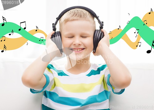 Image of smiling little boy with headphones at home