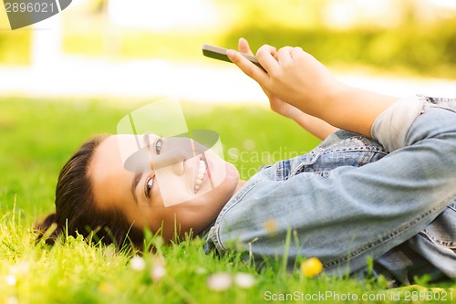 Image of smiling young girl lying on grass