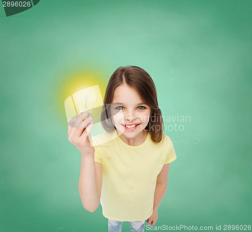 Image of smiling little girl holding light bulb