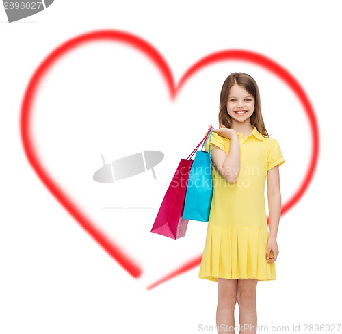 Image of smiling little girl in dress with shopping bags