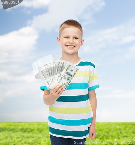 Image of smiling boy holding dollar cash money in his hand