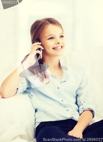 Image of smiling girl with smartphone at home