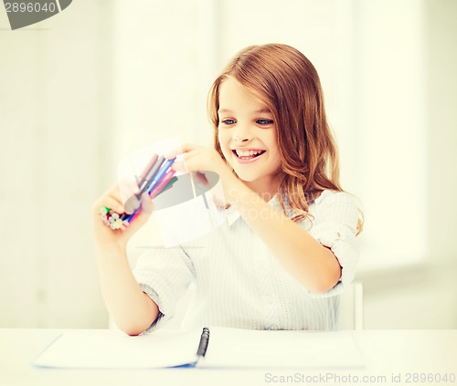 Image of smiling girl choosing colorful felt-tip pen