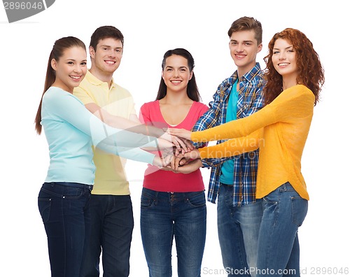 Image of smiling teenagers with hands on top of each other