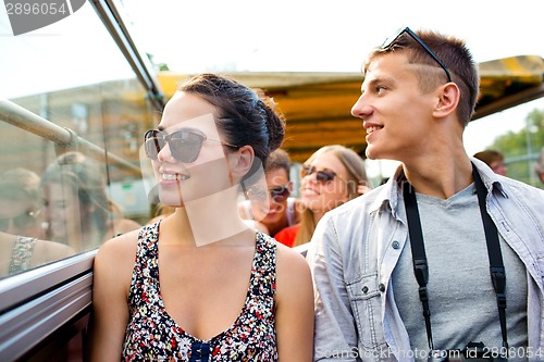 Image of smiling couple with camera traveling by tour bus