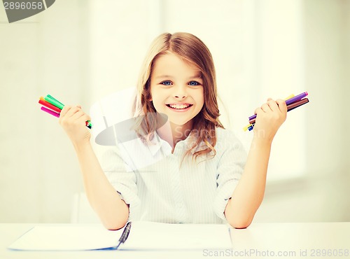 Image of smiling girl showing colorful felt-tip pens