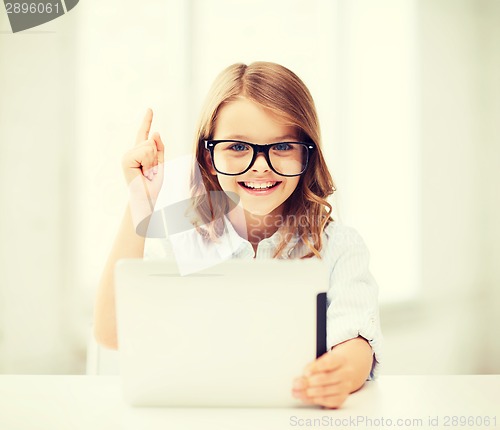 Image of smiling girl in glasses with tablet pc at school