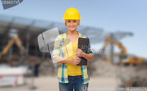 Image of smiling woman in helmet with clipboard