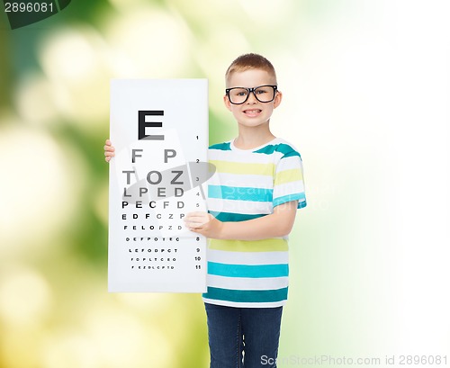 Image of smiling boy in eyeglasses with white blank board