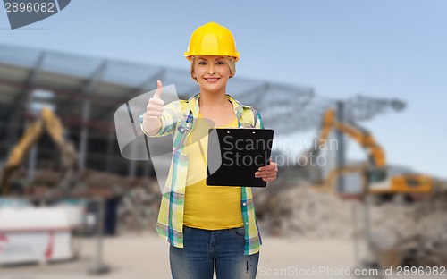 Image of smiling woman in helmet with clipboard