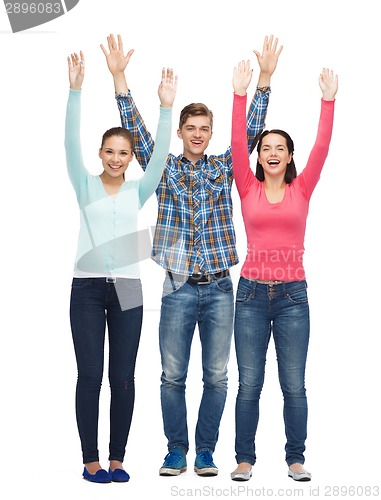 Image of group of smiling teenagers with raised hands
