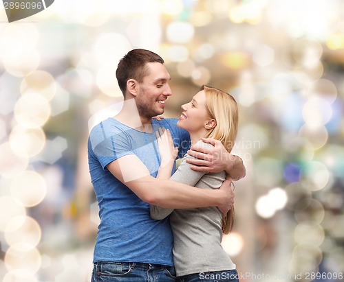 Image of smiling couple hugging and looking at each other