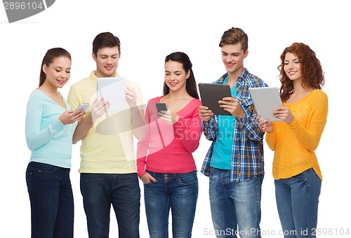 Image of group of teenagers with smartphones and tablet pc