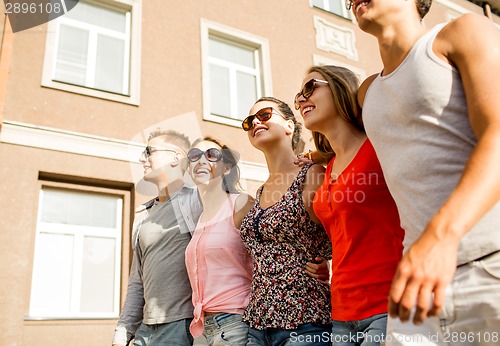 Image of group of smiling friends walking in city