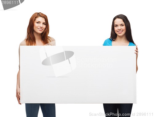 Image of two smiling young girls with blank white board