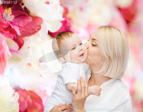 Image of happy mother kissing smiling baby
