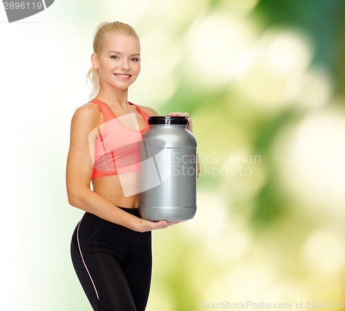 Image of smiling sporty woman with jar of protein