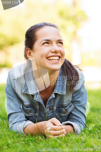 Image of smiling young girl lying on grass