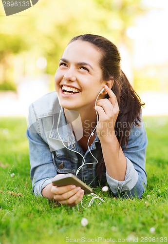 Image of laughing young girl with smartphone and earphones