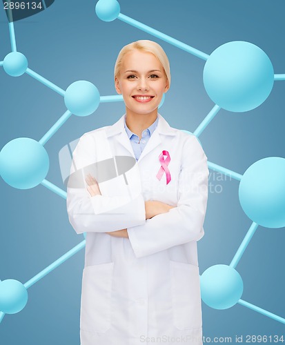 Image of smiling female doctor with cancer awareness ribbon