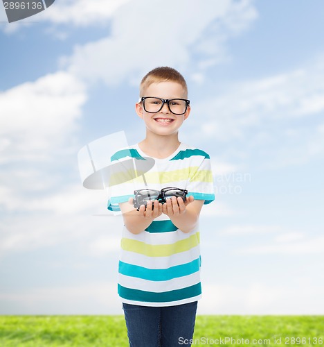 Image of smiling boy in eyeglasses holding spectacles