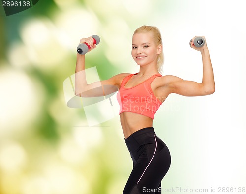 Image of smiling beautiful sporty woman with dumbbells