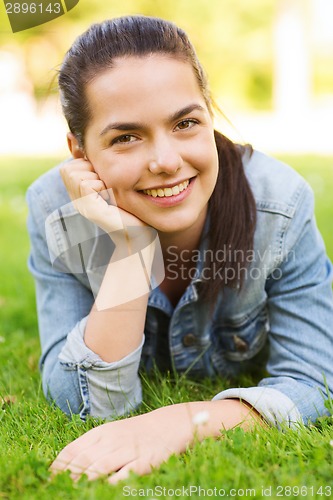 Image of smiling young girl lying on grass