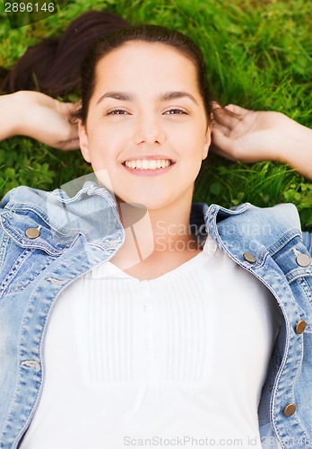 Image of smiling young girl lying on grass