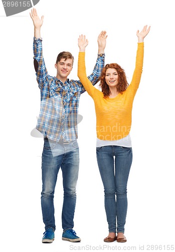 Image of smiling teenagers with raised hands