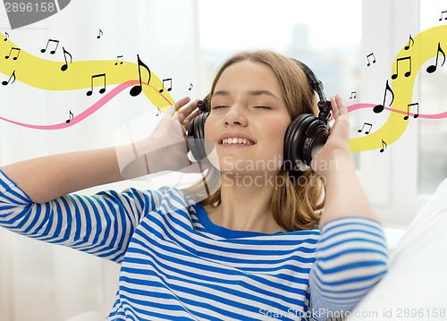 Image of smiling young girl in headphones at home