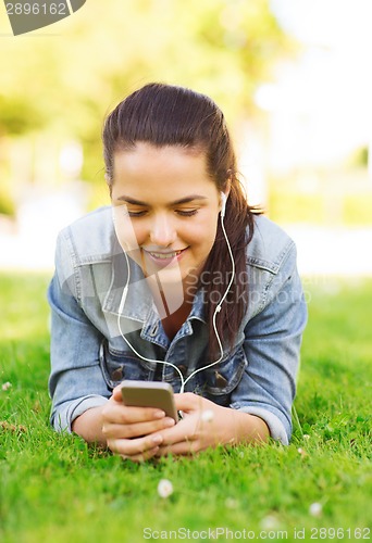 Image of smiling young girl with smartphone and earphones