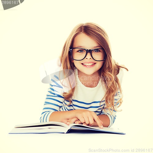 Image of smiling little student girl lying on the floor