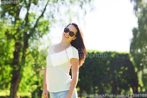 Image of smiling young woman with sunglasses in park