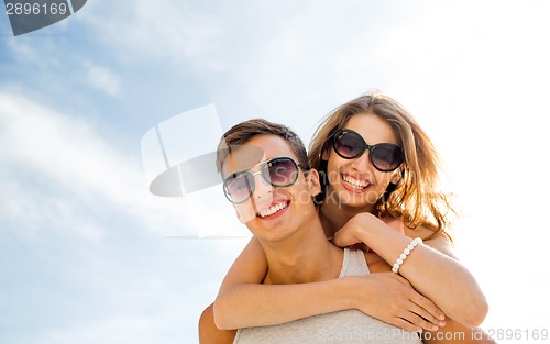 Image of smiling couple having fun over sky background