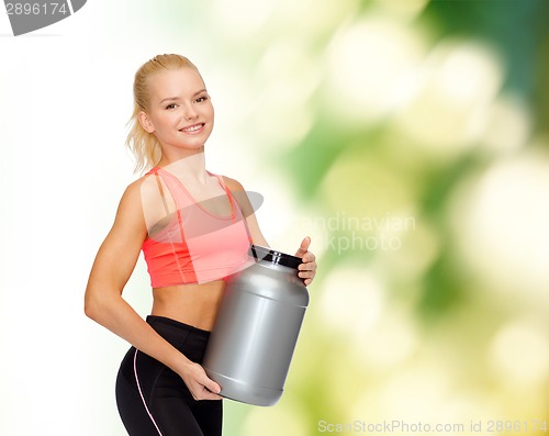 Image of smiling sporty woman with jar of protein