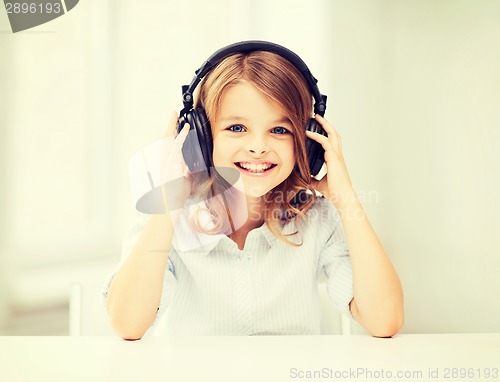 Image of little girl with headphones at home