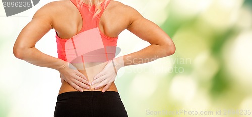 Image of close up of sporty woman touching her back