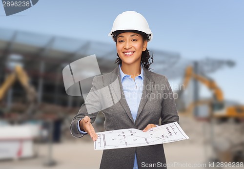 Image of businesswoman in white helmet with blueprint