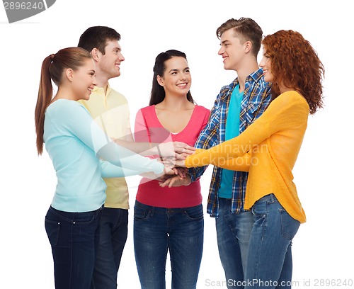Image of smiling teenagers with hands on top of each other