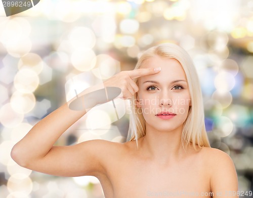 Image of beautiful woman touching her forehead