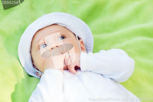 Image of litle baby lying on floor and looking up