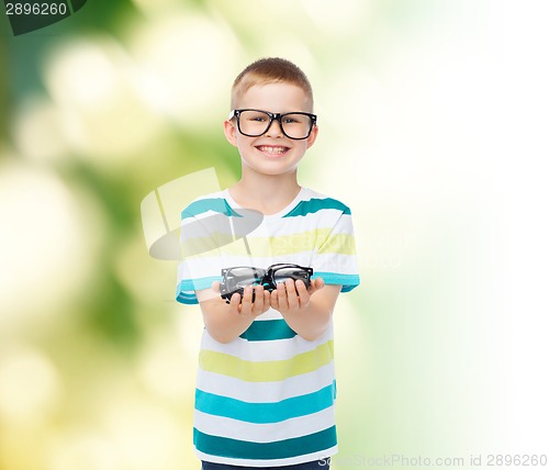 Image of smiling boy in eyeglasses holding spectacles