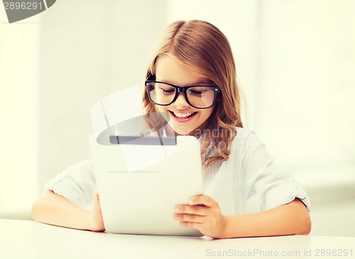 Image of smiling girl in glasses with tablet pc at school